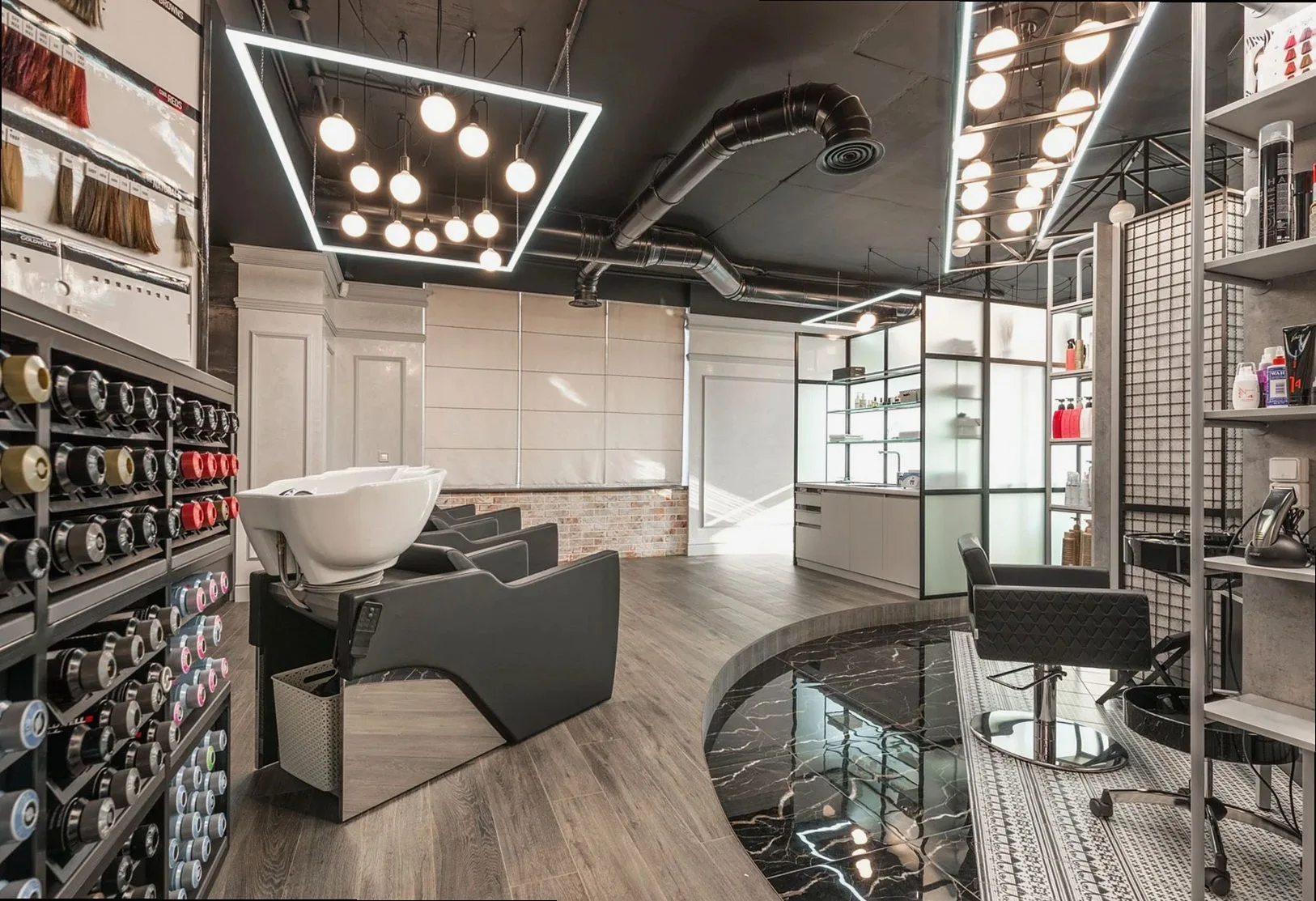 Black backwash chair with white sink placed in modern stylish beauty salon with various cosmetology products and bright 